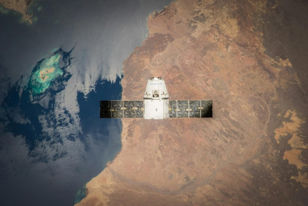 Satellite in orbit with detailed view of Earth and ocean below.