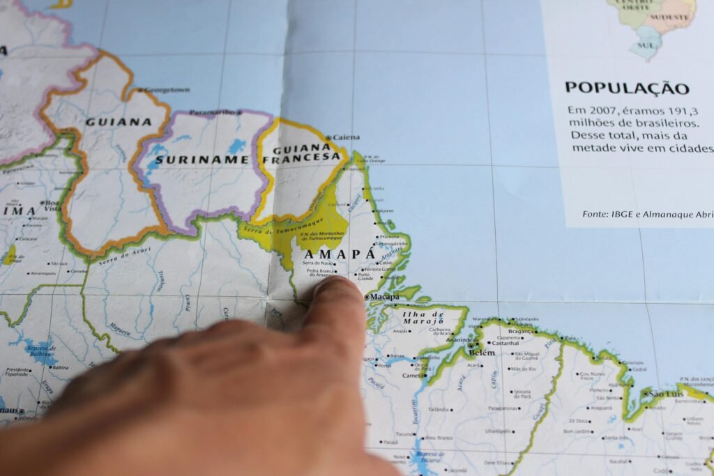 Close-up of a finger pointing at Amapá on a map of Brazil, highlighting geography.