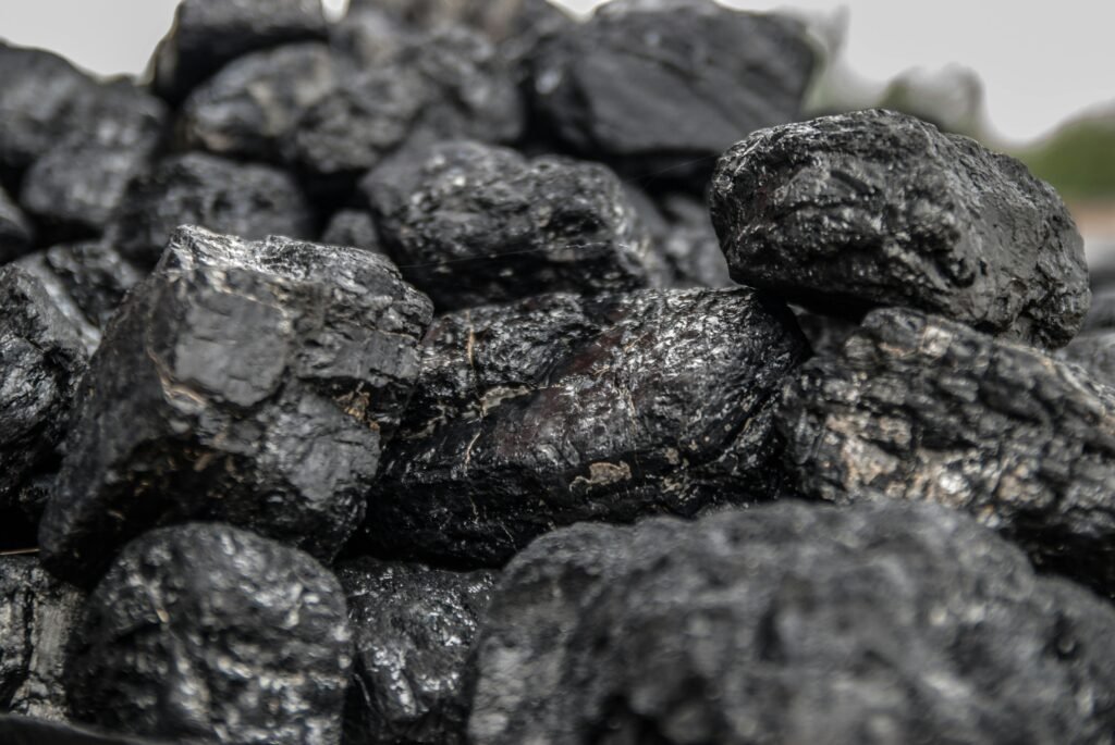 Detailed image of dark, textured coal pieces in a close-up view, highlighting their rugged surface.