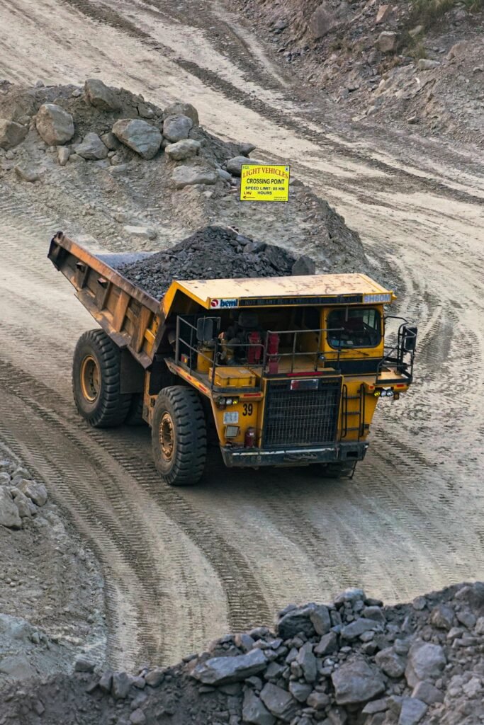 Heavy mining truck transporting minerals in a rocky open-pit quarry in Bahula, West Bengal.